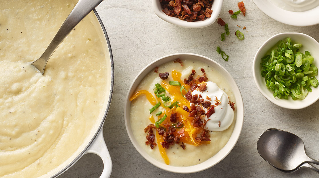Loaded Mashed Potato Soup and ingredients on a table top
