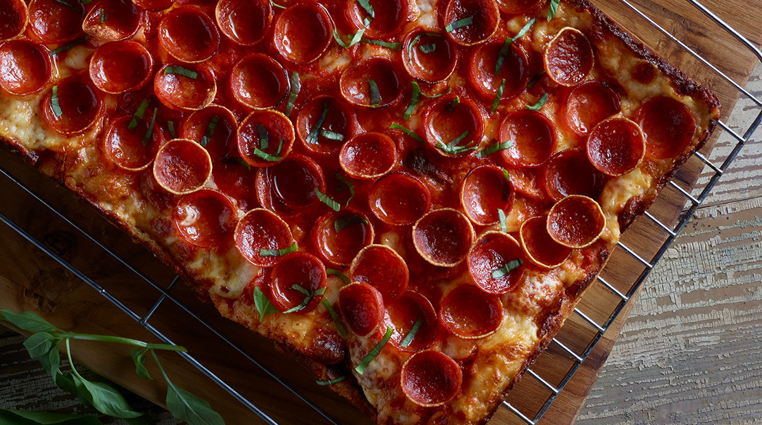 Detroit-style pizza with red curry tomato sauce, pepperoni and Thai basil