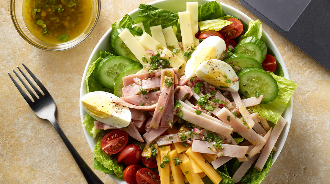 overhead of salad at a table with laptop