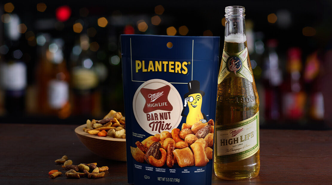 A bottle of Miller High Life beer next to a bag of Planters® Miller High Life trail mix.