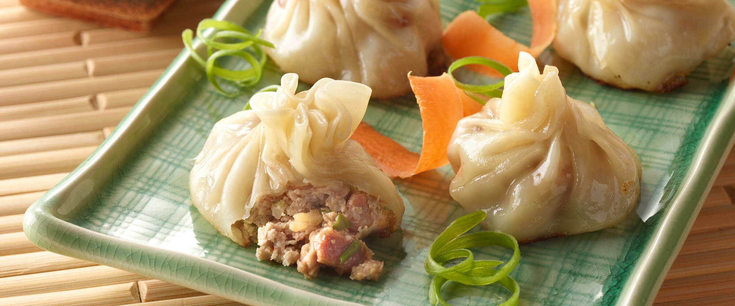 Pork dumpling on a green plate with garnish