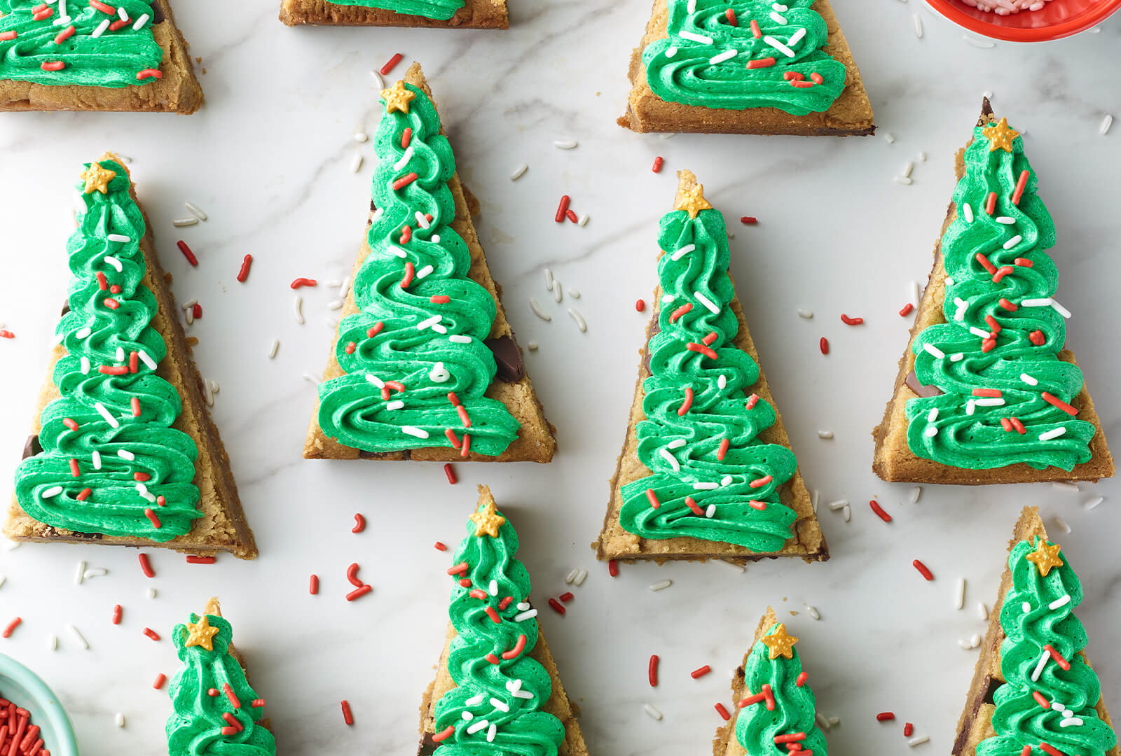 11 Browned Butter Peanut Butter Chocolate Chunk Bars topped with green frosting on a marble counter top.