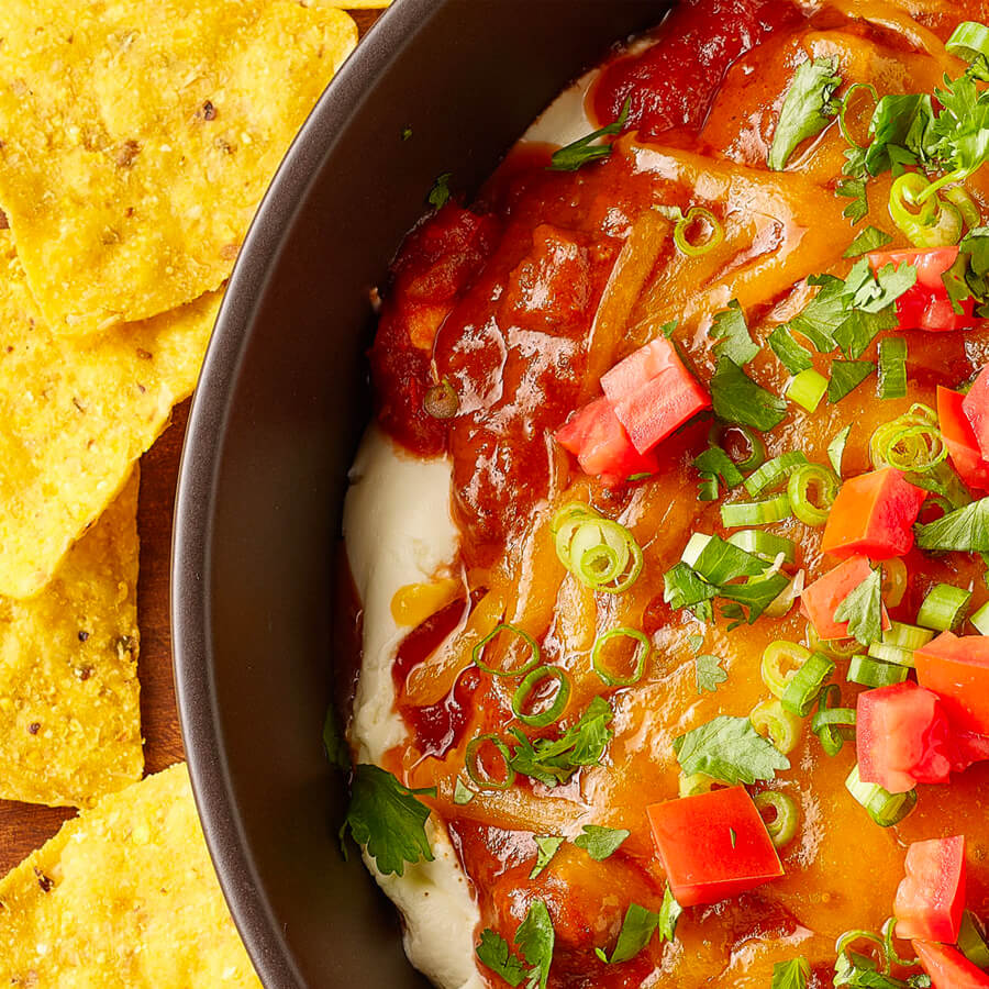 7 layer chili dip in skillet with chips