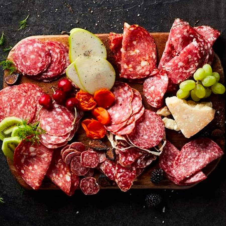 a cutting board with a ton of cold cuts on it
