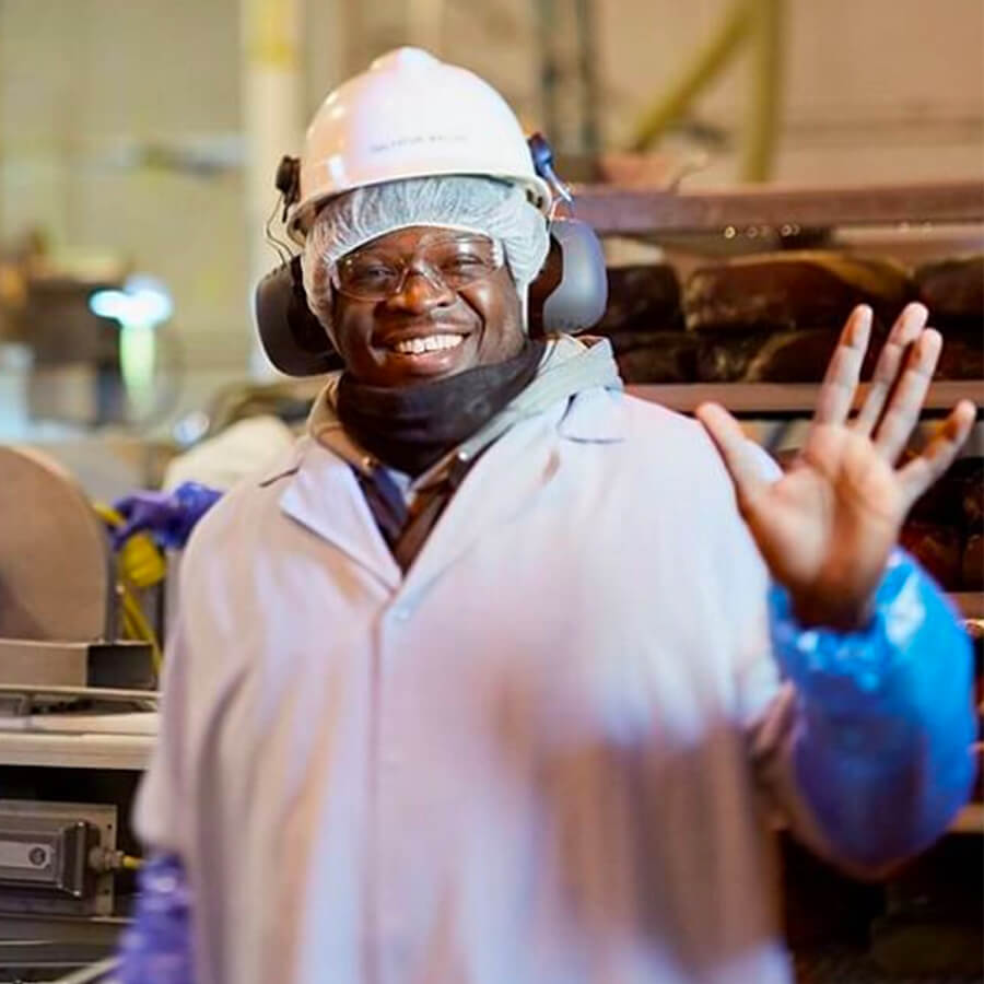 a friendly plant worker waves at the camera