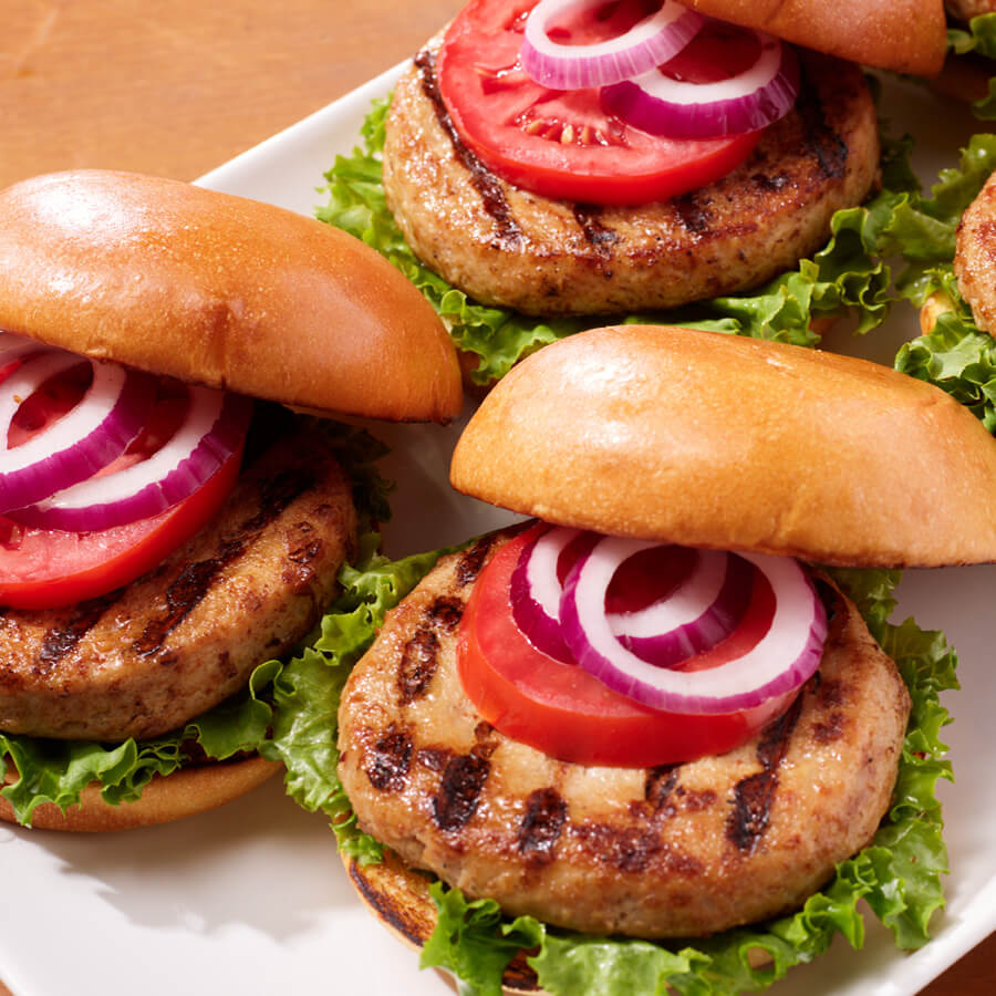 Platter of burgers with tomato and onion