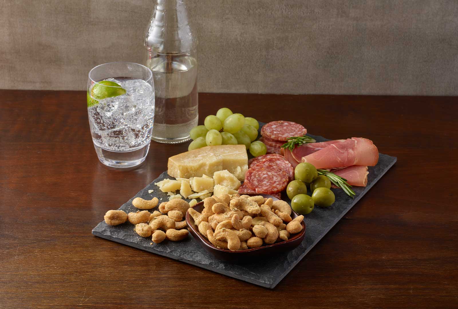 A charcuterie board featuring the new Planters Rosemary cashews