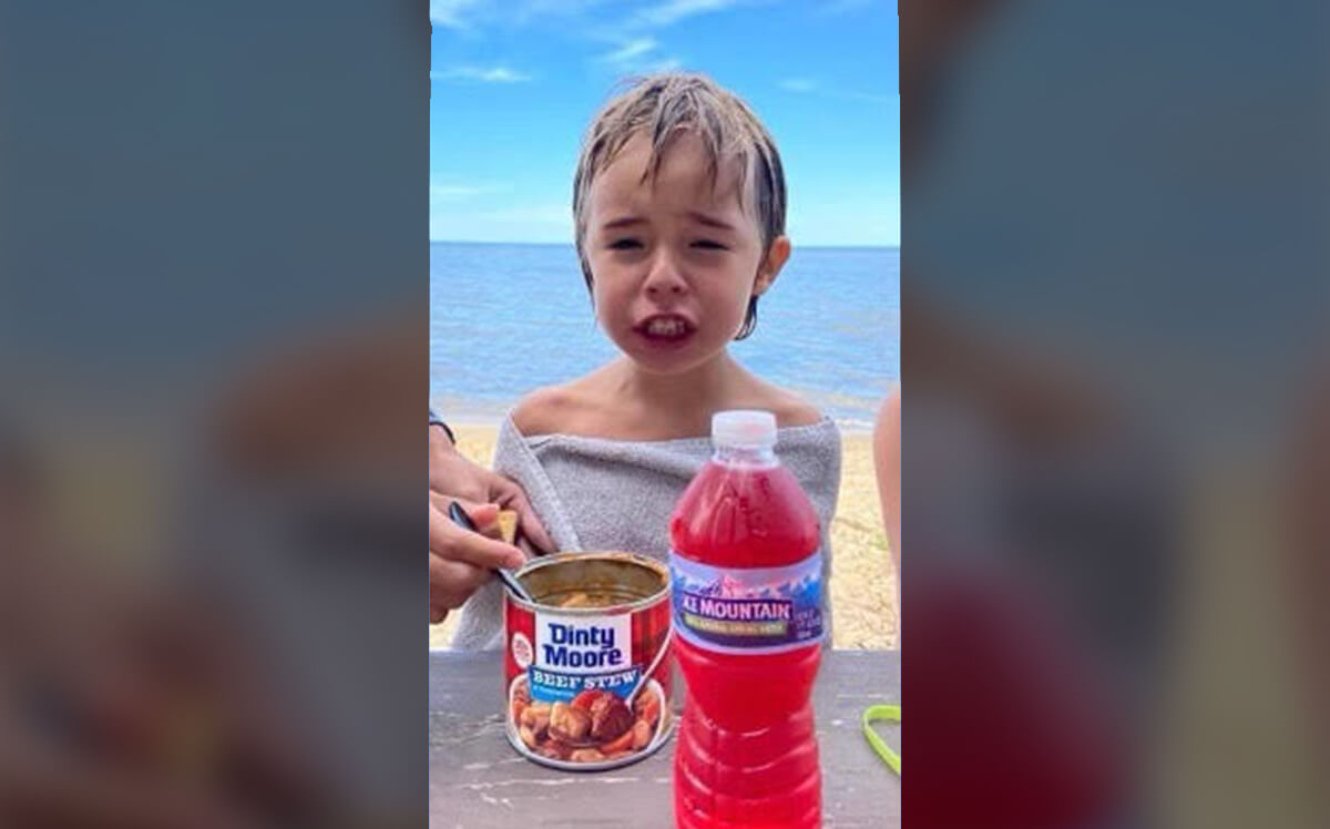 Danny Young eating Dinty Moore at the beach