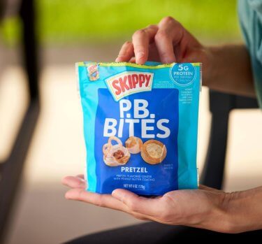 Hand reaching for SKIPPY<sup>®</sup> P.B. Pretzel Bites