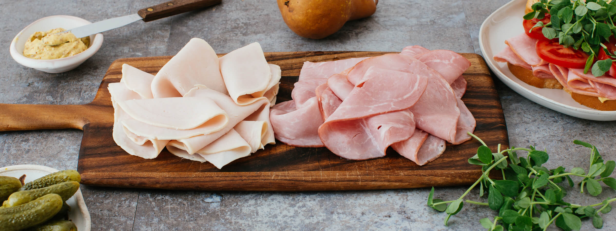 a serving board with turkey and ham slices