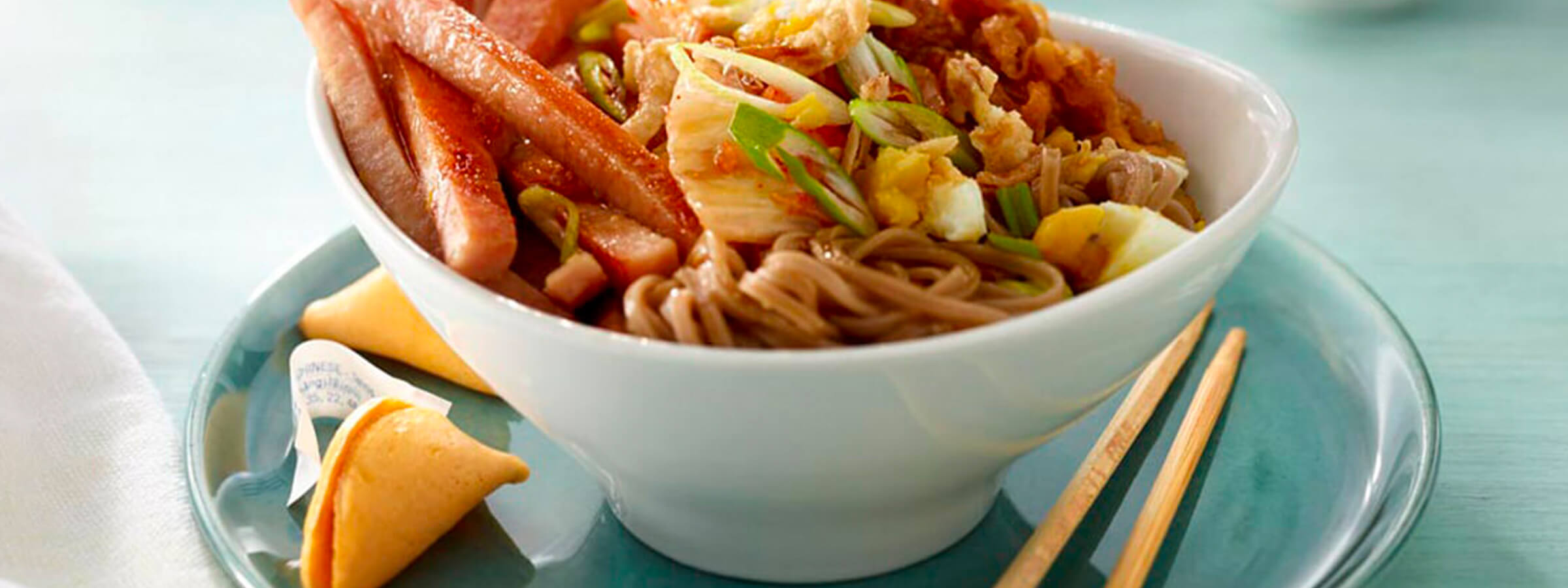 An asian bowl of noodles with Spam slices