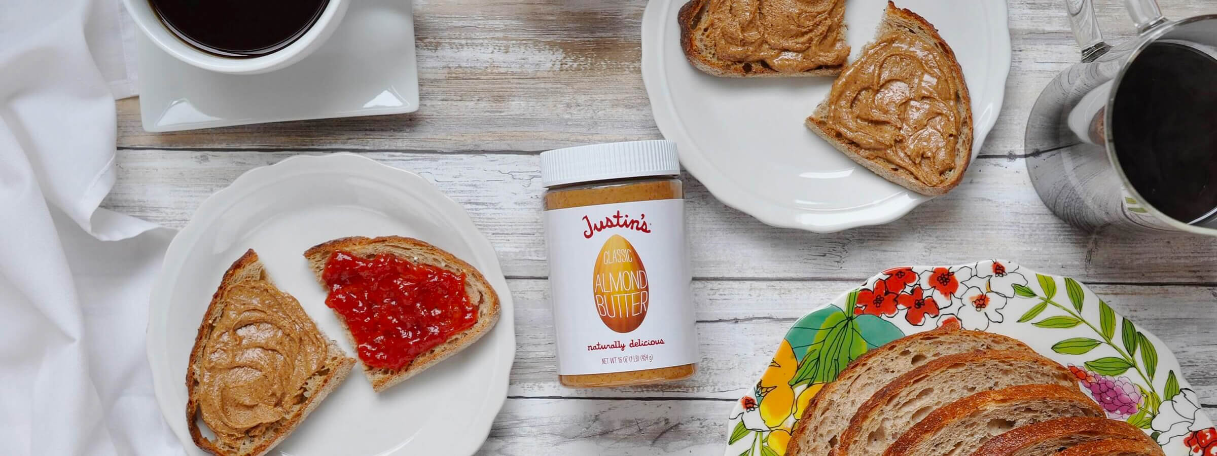 A jar of Justin's PB with some plates of toast surrounding it