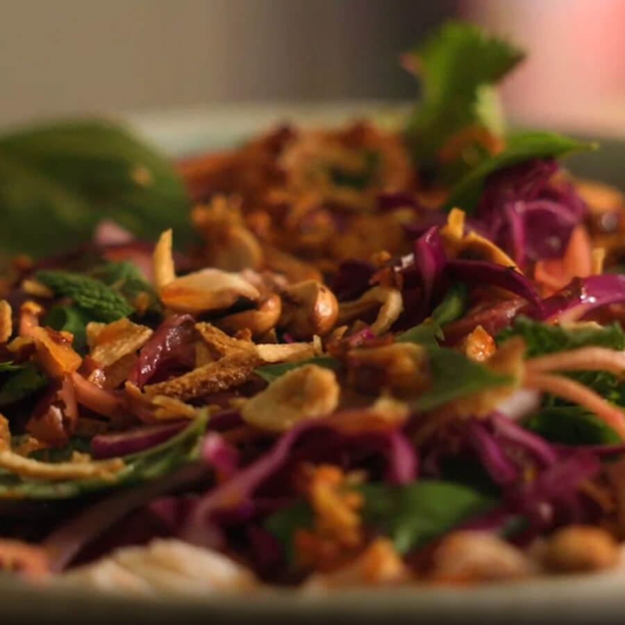 close crop of salad in white bowl with red cabbage & greens