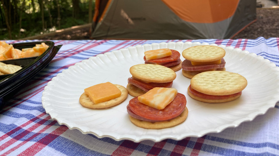 Party tray on picnic table with tent in the background