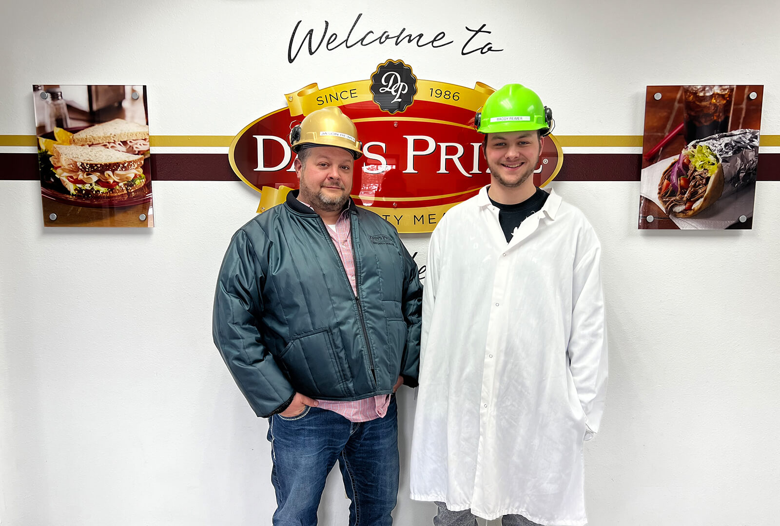 Jason and McCoy Reimer together in front of a Dan's Prize sign