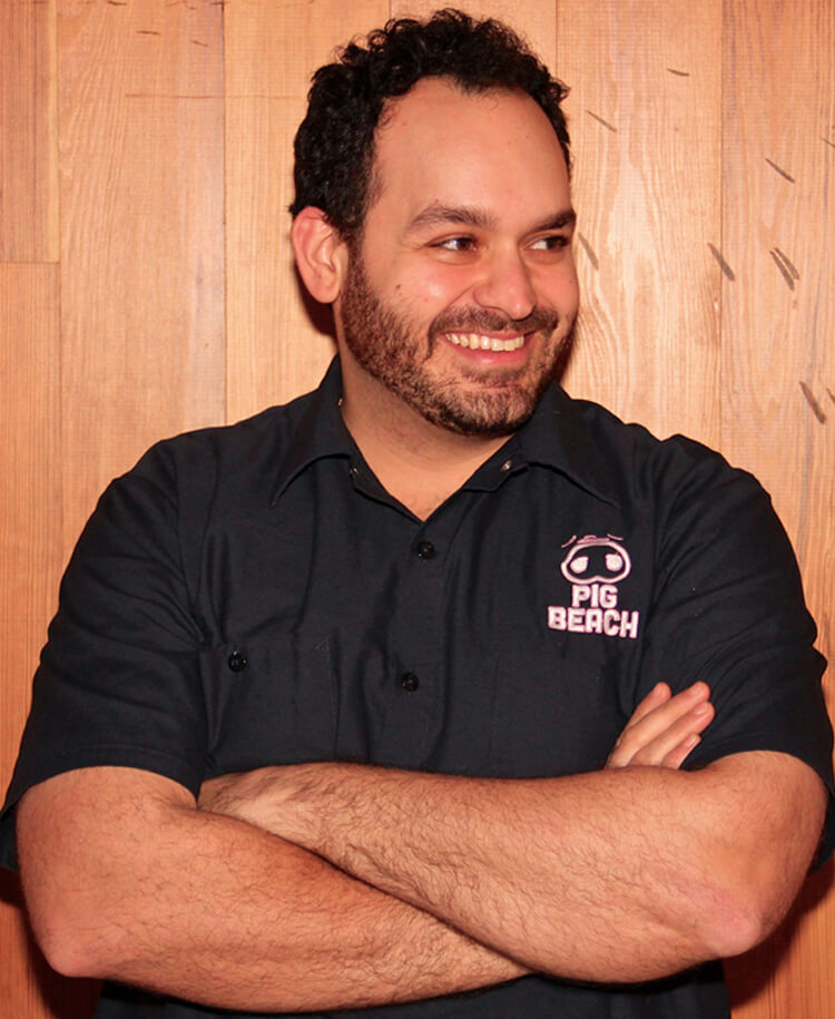 Matt Abdoo standing in front of a wooden wall