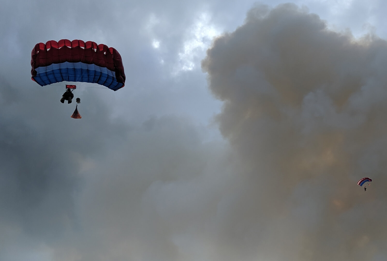 A smokejumper parachuting down into a fire
