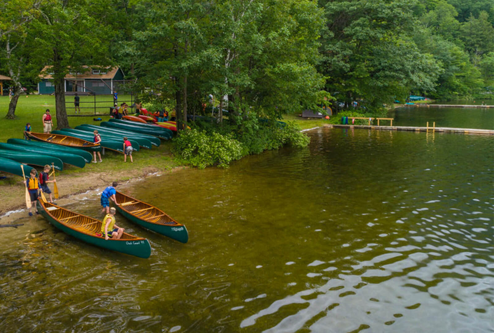 Several canoes on the shore of a lake